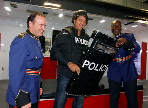 BORIS MINKEVICH / WINNIPEG FREE PRESS
Andrew Scott, middle, from Jamaica, became a Canadian Citizen today at a special citizenship ceremony held at the Winnipeg Police Service Headquarters as part of Canada 150. After the official ceremony the new Canadians were given a tour of some police stuff. Here Chief of Police Danny Smyth, left,  shows Scott what some of the police equipment feels like. On right is Cont. Misan Odidison. Sept. 19, 2017