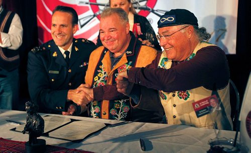 PHIL HOSSACK / WINNIPEG FREE PRESS  - David Chartrant, President of the Manitoba Metis Federation  (centre) RCMP Deputy Commissioner, Contract and Aboriginal Policing, Kevin Brosseau (left) and Clement CHartier, Persident of the National Metis Counsel sign an agreement returning artifactsfrom the  the RCMP to the Metis Saturday. See story.   - Sept 23, 2017