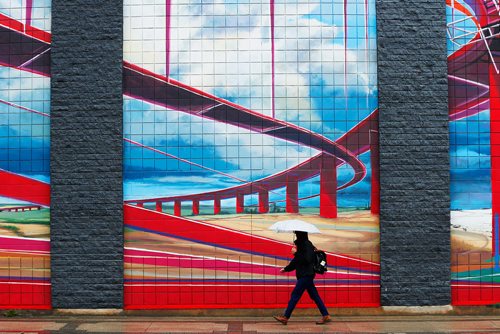 JOHN WOODS / WINNIPEG FREE PRESS
A pedestrian takes shelter from the rain as he walks past a Sherbrook Street mural by Michel Saint Hilaire Tuesday, September 26, 2017. Temperatures and sunshine should increase for the rest of the week,