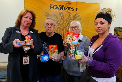 BORIS MINKEVICH / WINNIPEG FREE PRESS
From left, Winnipeg Harvest executive director Kate Brenner, James Clawson, Joey-Jayne Hyltun, and 
Steevy Rose pose with some of the top 10 thing people need at the food bank. Sept. 27, 2017