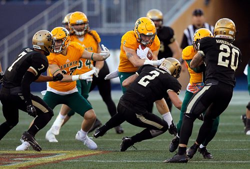 PHIL HOSSACK / WINNIPEG FREE PRESS  -  Alberta Golden Bear Edward Ilnikki i#4 is hit by Manitoba Bison #2 Rennie Houston as he looks for room running through the Manitoba Bisons defence Friday afternoon at the Investors Group Stadium. - Sept 29, 2017