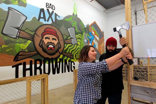 BORIS MINKEVICH / WINNIPEG FREE PRESS
Jen Zoratti, left, tries throwing an axe! In advance of the World Championship play downs with will be happening Oct. 9th and 10th. Jen gets a lesson from Ace Master Dan Blair, right, at Bad Axe Throwing, 1393 Border Street Unit #6. Oct 4, 2017