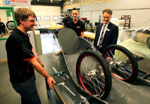 BORIS MINKEVICH / WINNIPEG FREE PRESS
RRC students Riley McLeod, left, and Brad Thidrickson, middle, show some key components of the battery-electric vehicle that is being built to race in the 2018 Shell Eco-Marathon Challenge in California next April. Right, Paul Vogt, President and CEO of RRC, gets a quick lesson on the vehicle. The Eco-Car Race Team is made up of students from Red River Colleges Mechanical Engineering Technology program. Photo taken at Red River College's Notre Dame campus. Oct 4, 2017