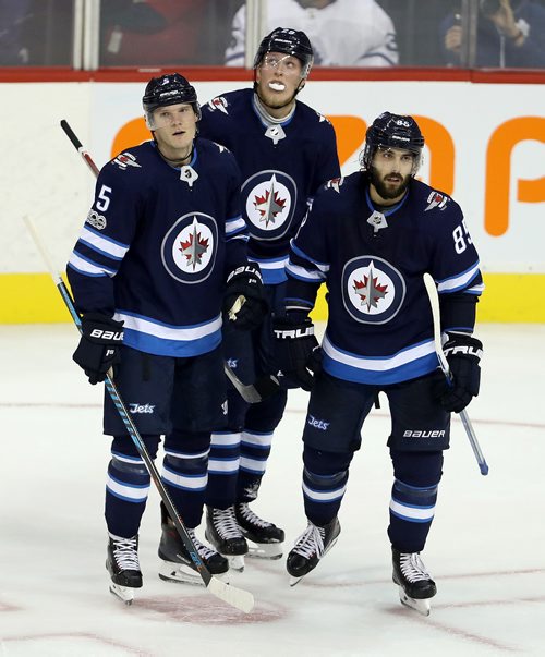 TREVOR HAGAN / WINNIPEG FREE PRESS
Winnipeg Jets' Dmitry Kulikov (5), Patrik Laine (29) and Mathieu Perreault (85) look disinterested as they celebrate Perreault's goal during third period NHL hockey action against the Toronto Maple Leafs' on the opening night, Wednesday, October 4, 2017.