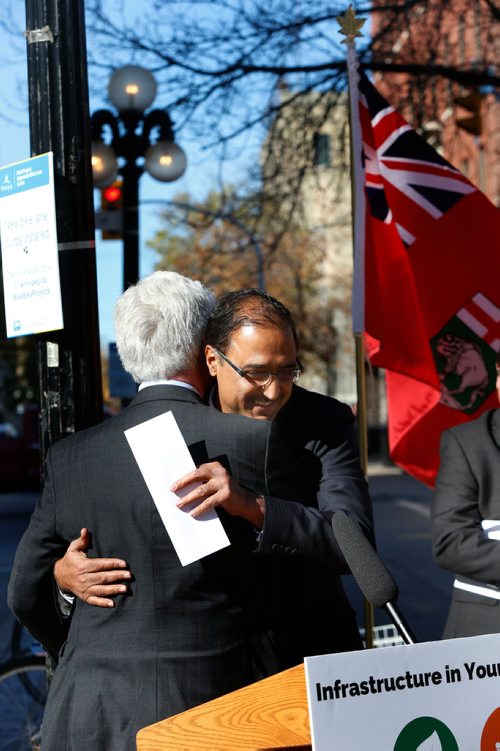 WAYNE GLOWACKI / WINNIPEG FREE PRESS

 At right, Amarjeet Sohi, Minister of Infrastructure and Communities embraces Jim Carr, MP for Winnipeg South Centre at a infrastructure announcement Tuesday in Old Market Square. Larry Kusch story  Oct.10 2017