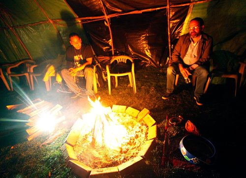 PHIL HOSSACK / WINNIPEG FREE PRESS  -  Firekeepe rKirby Nelson (left) keeps the flame burning Tuesday night  while Commisioner Brian Eyolfson sits with him at the Forks for the Murdered and Missing Aborigional Commision hearings. See Melissa Martin story.  - Oct 17, 2017