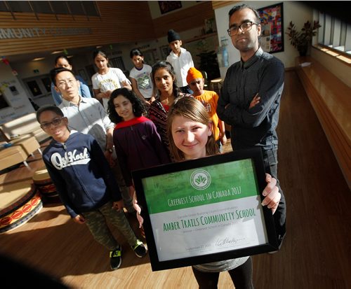 PHIL HOSSACK / WINNIPEG FREE PRESS  -  A pround grade six student Elizabeth Terry holds her school's award as the Greenest School in Canada.  Teachers Simon Hon (Left) and  Shivram Raveendabrose (right) pose with students from grades 3-8 at the K-8 Amber Trails Community School. The school is the "Geenest" in Canada. See story.  - Oct 18, 2017