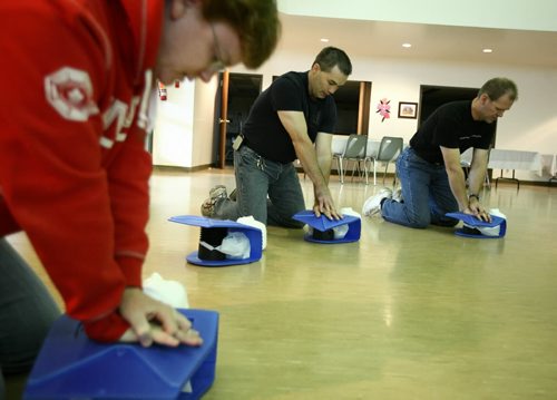 Brandon Sun 18102008 Reverend Shannon McCarthy, Murray Spratt, and Todd Ward, the past chair for the Central United Church Board, all practice their CPR skills during St. John's Ambulance training at the church on Saturday afternoon. The group also learned how to use a defibrillator and have purchased one for the church. (Tim Smith/Brandon Sun)