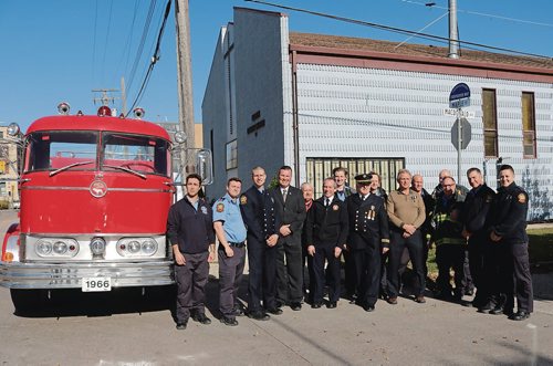 Canstar Community News Oct. 18, 2017 - Winnipeg fire fighters gather with United Fire Fighters of Winnipeg Local 867 vice-president Tom Bilous, Winnipeg Fire Paramedic Service chief John Lane and Winnipeg Firefighters Historical Society pas president Ted Kuryluk in front of the honourary street sign naming Maple Street from Higgins Avenue to Henry Avenue as Firefighter Way. (LIGIA BRAIDOTTI/CANSTAR COMMUNITY NEWS/TIMES)