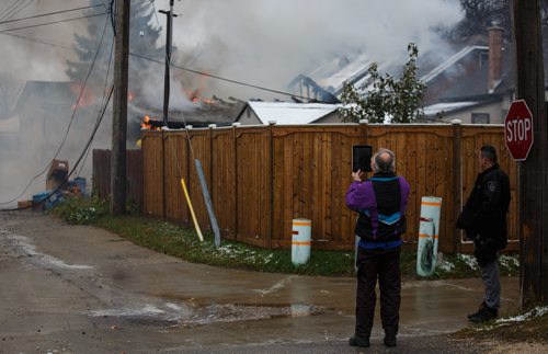 MIKE DEAL / WINNIPEG FREE PRESS
A passerby uses his tablet to record a video while WFPS crews work on putting out a garage fire in the 600 block of Church Avenue Thursday afternoon.
171026 - Thursday, October 26, 2017.