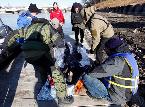 PHIL HOSSACK / WINNIPEG FREE PRESS  - Recuers huddle around a hypothermic victim  friday afternoon as part of a hypothermia rescue program offered to RCMP and WPS members, see release.The "victim" was well insulated and warm inside a dry suit for the demonstration. - November 3, 2017

LOCAL STDUP - water rescue training

PROFESSOR POPSICLE TEACHING RCMP, WPS MEMBERS BEYOND COLD WATER BOOT CAMP

Cold water rescue demonstrations Friday afternoon in the Red River 


University of Manitoba Faculty of Kinesiology Professor Gordon Giesbrecht is known better by his nickname Professor Popsicle, thanks to his renowned research and teaching on the effects of cold water on the body. This fall, he published his 100th paper in a peer reviewed journal on the topic.



Dr Giesbrecht has offered a Beyond Cold Water Boot Camp across Canada to members of the lifesaving community for the past number of years, and for the first time this week, hes offering it in Winnipeg.



30 enrollees from the Winnipeg Police Service, RCMP, Red Cross and the Lifesaving Society attended day one of the course yesterday, and will continue their training today (Friday, November 3, 2017).



The two-day course includes classroom work in the morning and rescue training in the Red River in the afternoon, with RCMP boats and victims in the water being rescued and treated on shore.



Were training emergency responders including law enforcement personnel, search and rescue members, and other educators about the dangers of cold water immersion and how to rescue and treat people who are in cold water, said Giesbrecht. Were demonstrating different types of emergency gear, and weve got three RCMP boats helping us simulate real rescue situations.


One of the things were working on is exploding some of the myths around what really are dangers of cold water immersion and how to safely extract someone from the cold. And despite some popular opinion, were showing that