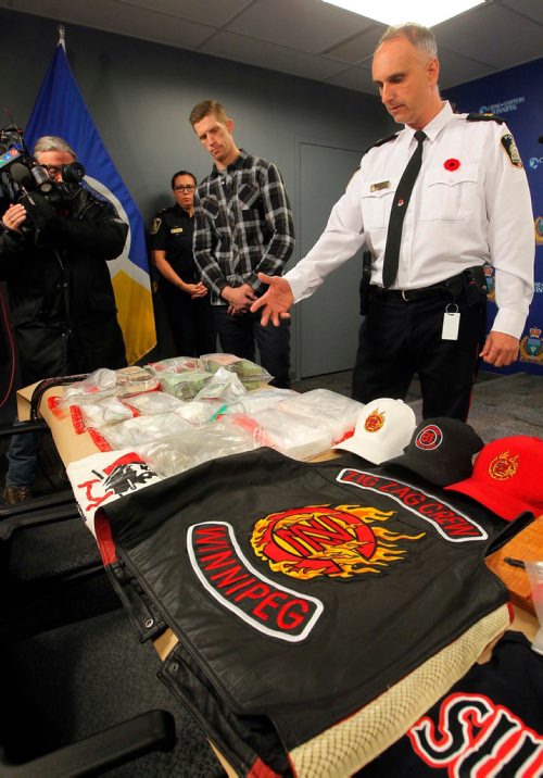 BORIS MINKEVICH / WINNIPEG FREE PRESS
Police display drugs, cash, and gang material at Winnipeg Police Headquarters at this morning's press conference. From left, detective Steve Mitchell, in plaid, and Inspector Max Waddell with the stuff. Nov. 10, 2017