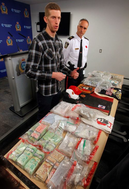 BORIS MINKEVICH / WINNIPEG FREE PRESS
Police display drugs, cash, and gang material at Winnipeg Police Headquarters at this morning's press conference. From left, detective Steve Mitchell, in plaid, and Inspector Max Waddell with the stuff. Nov. 10, 2017