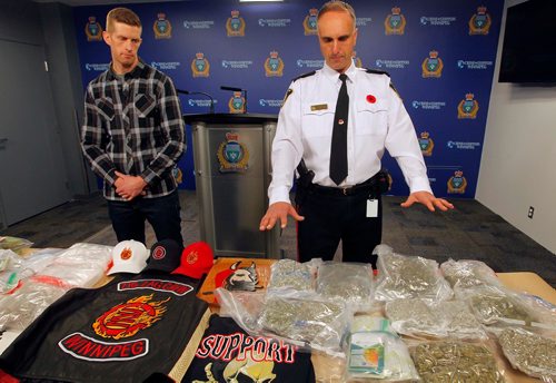BORIS MINKEVICH / WINNIPEG FREE PRESS
Police display drugs, cash, and gang material at Winnipeg Police Headquarters at this morning's press conference. From left, detective Steve Mitchell, in plaid, and Inspector Max Waddell with the stuff. Nov. 10, 2017