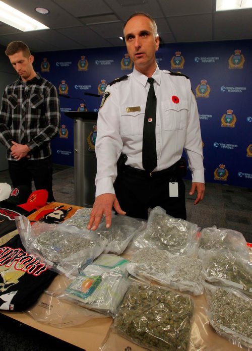 BORIS MINKEVICH / WINNIPEG FREE PRESS
Police display drugs, cash, and gang material at Winnipeg Police Headquarters at this morning's press conference. From left, detective Steve Mitchell, in plaid, and Inspector Max Waddell with the stuff. Nov. 10, 2017