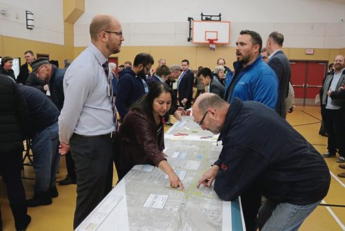 Canstar Community News Nov. 7, 2017 - Public Works transportation and planning engineer Scott Suderman (left) and Old Kildonan ward coun. Devi Sharma (second left) engage with community members at the Chief Peguis Trail Extension information session on Nov. 7 at Red River Community Centre. (LIGIA BRAIDOTTI/CANSTAR COMMUNITY NEWS/TIMES)