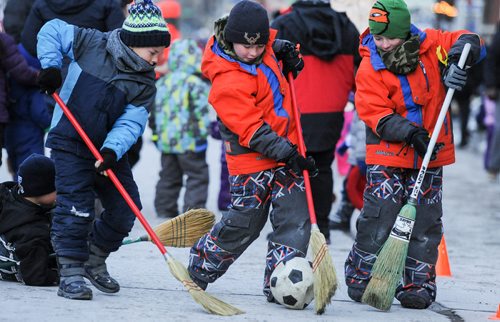 A few boys play broom ball as they anxiously await the turn of Santa Claus and the 2017 Santa Claus Parade Saturday evening. November 18, 2017. Mike Sudoma / Winnipeg Free Press