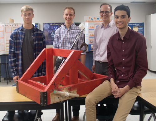 Canstar Community News Grade 12 physics students at Mennonite Brethren Collegiate Institute built functional catapults as part of their coursework. Students compete by attempting to hit a target five times in a row at five different distances. Students Matt Leppelmann, Lucas Mosienko, and Emmit Hameed were the first group to hit 5/5 targets in the 20 years that Andrew Hiebert, head of science department at MBCI, has been organizing the competition. Pictured, from left, Leppelmann, Mosienko, Hiebert, and Hameed. (SHELDON BIRNIE/CANSTAR/THE HERALD)