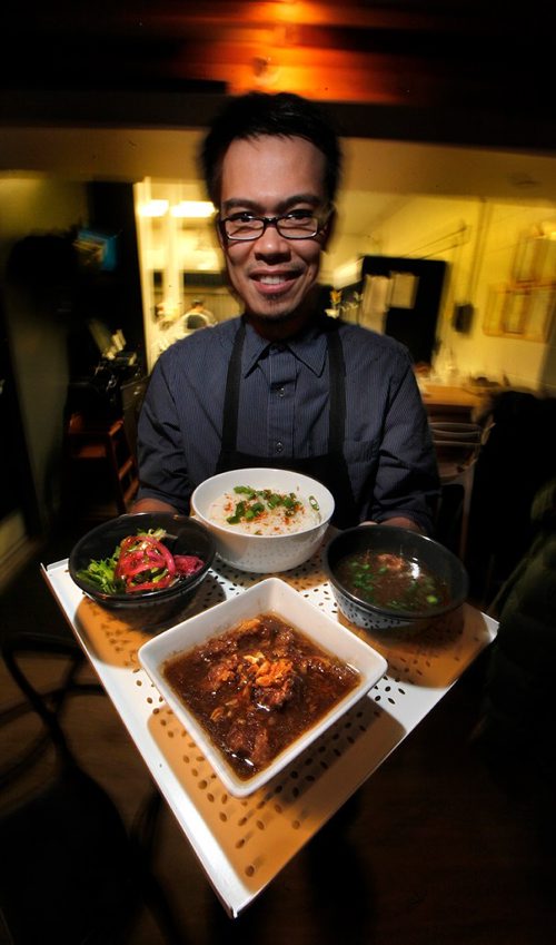 PHIL HOSSACK / WINNIPEG FREE PRESS
Mami Project co-owner Gian Pau shows off the beef pares platter featuring beef, broth, garlic rice and salad.
