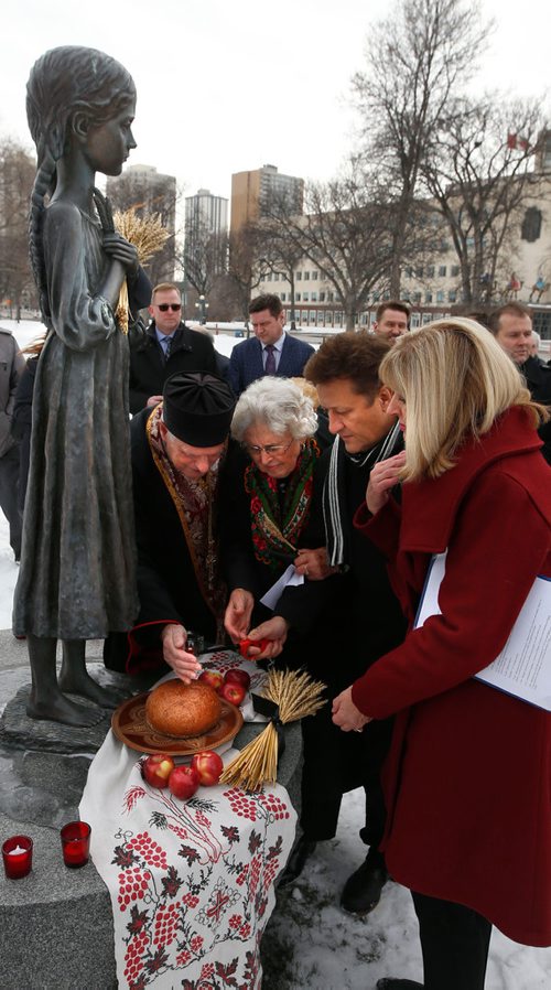 WAYNE GLOWACKI / WINNIPEG FREE PRESS

From right, Minister Cathy Cox, Ron Schuler, MLA, Sonia Kushliak and Monsignor Michael Buyochok light a candle by The Bitter Memories Of Childhood monument on the Manitoba Legislative grounds for a ceremony Thursday to remember the Ukrainian famine genocide of 1932 to 1933. Sonia of Winnipeg is a Holodomor survivor who was eight years old in Ukraine when the famine began.  During the Soviet governments regime, millions of Ukrainians starved to death during the Holodomor, which translates into death by hunger. Manitoba is among jurisdictions around the world that formally commemorate the Holodomor annually on the fourth Saturday of November, known in Manitoba as Ukrainian Famine and Genocide (Holodomor) Memorial Day. This year it takes place  on Nov. 25.  During Thursdays question period, Sport, Culture and Heritage Minister Cathy Cox introduced a moment of silence and stalks of wheat, tied with a black ribbon were placed on the desk of every member of the legislative assembly. See Manitoba Govt release story.  Nov. 23  2017