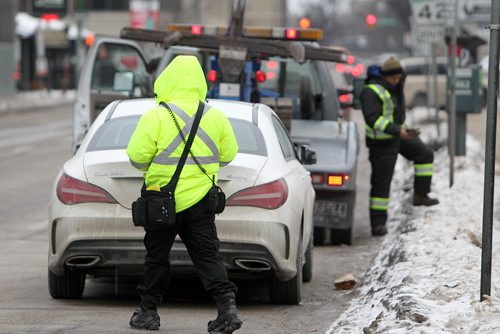 RUTH BONNEVILLE / WINNIPEG FREE PRESS

Visuals for story on parking rates going up in Winnipeg.
Photo of parking patrol on Donald issueing  a ticket as towing company prepares to tow vehicle.  
See parking rate hike story.  
Nov 23, 2017