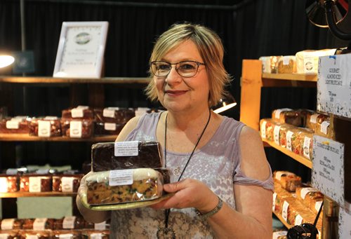 RUTH BONNEVILLE / WINNIPEG FREE PRESS

48.8 Patti Cakes
 Portrait of Patti Marcq, owner of Patti Cakes with a few of her gourmet fruit cakes she's selling at the Signatures Craft Show at the Convention Centre Saturday,   
Sidebar story on Patti, owner of Patti Cakes, a Reston, Mb-based biz  that has been in business for many years and ships fruit cakes across the country, this time of year. 
For story.  
Nov 25, 2017