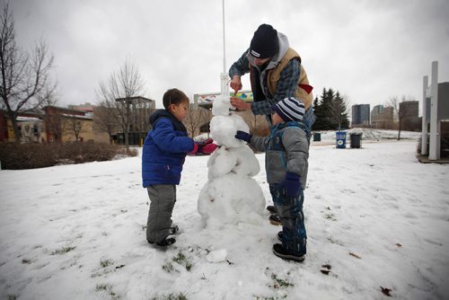 RUTH BONNEVILLE / WINNIPEG FREE PRESS

Brothers Satya (4yrs) and Akili (2yrs) Mapu enjoy putting the finishing touches on a snow man they made at the Forks Monday afternoon while spending time with family and friends in the balmy weather. 
Adult in photo is friend of family Nick Kohuck.  
Standup photo 

Nov 27, 2017