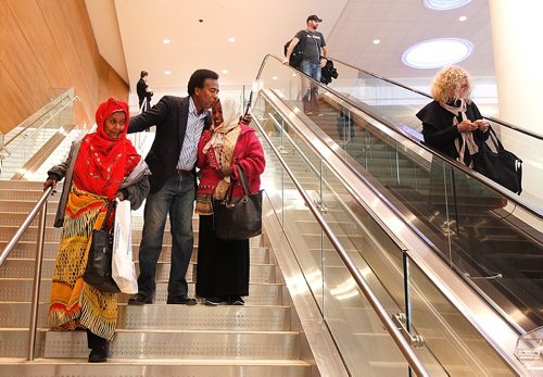 PHIL HOSSACK / WINNIPEG FREE PRESS  -  Marcos Askar ran up the arrival stairs to assist his aunt and  the family matriarch his aunt Badar Asha Askar (60) and kiss his cousin Hannah Rageh  Askar, as members of his clan arrivied at Winnipeg's Richardson International Airport Tuesday. Jane Gerster story.   - November 28, 2017