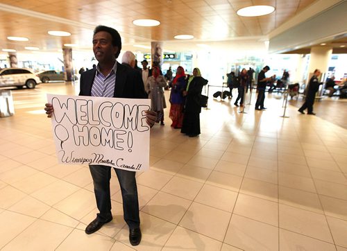 PHIL HOSSACK / WINNIPEG FREE PRESS  -  Marcos Askar stands holding a welcoming sign for nine members of his clan arriving at Winnipeg's Richardson International Airport Tuesday. Cousins and the family matriarch his aunt Farah Mahmoud (60) arrived after a decades long seperation.   - November 28, 2017