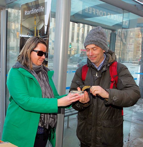 BORIS MINKEVICH / WINNIPEG FREE PRESS
A coalition of Winnipeg groups is launched the Sardine Award campaign at the corner of Donald and Broadway to draw attention to the dire state of Winnipeg Transit in the wake of a massive fare increase and significant planned service cuts announced in Mayor Brian Bowmans 2018 budget, which goes to vote on December 12th. From left, Winnipeg Labour Council president Basia Sokal and Josh Brandon, Community Animator at Social Planning Council of Winnipeg, with a can of sardines. ERIK PINDERA STORY Nov. 30, 2017