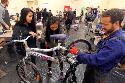 BORIS MINKEVICH / WINNIPEG FREE PRESS
From left, Hugh John MacDonald School grade 9 students Mika Lazaro and Tenderly Tenderly work with bike mechanic Richard Helbig work on a bike at the 24-hour kids' bike-building marathon. The event from noon Saturday to noon Sunday, at the Orioles Community Centre at 448 Burnell St. Over 350 volunteers of which there were 150 bike mechanics were involved. The goal is to build over 300 bikes in 24hrs. The WRENCH program organized it. STANDUP PHOTO  Dec. 2, 2017

Tenderly Tenderly is her name. Triple checked.