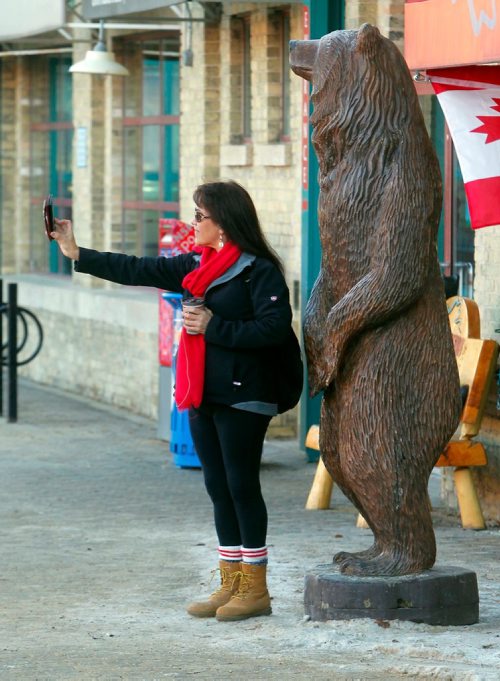 BORIS MINKEVICH / WINNIPEG FREE PRESS
Dawn Flett takes a selfie with the wood carved bear at the Forks. STANDUP PHOTO  Dec. 2, 2017