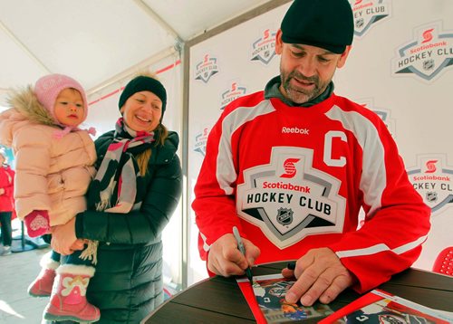 BORIS MINKEVICH / WINNIPEG FREE PRESS
The Rogers Hometown Hockey Tour at the Forks. From left, 18 month old Veronica Minkin with her mom Natalya get an autograph signed by old Winnipeg Jets player Kris King at the event. STANDUP PHOTO  Dec. 2, 2017