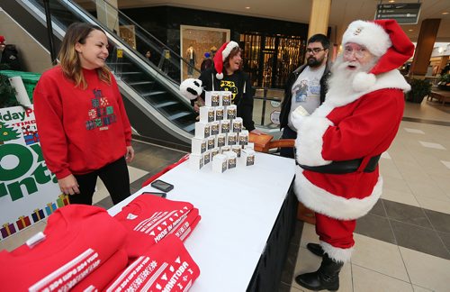 JASON HALSTEAD / WINNIPEG FREE PRESS

Polo Park's Santa Claus checks out Coal and Canary's Peg Nog candles as CTV intern Meghan Kjartanson staffs the sales table at the Salvation Army's Toy Mountain gift drive at Polo Park on Dec. 1, 2017. (See Social Page)