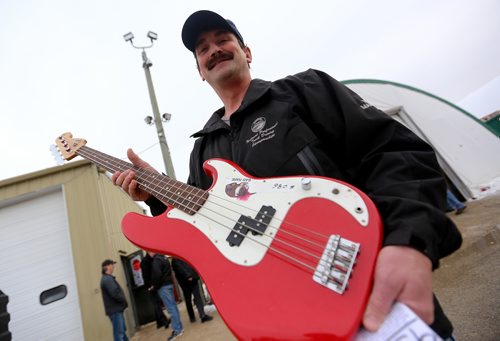 TREVOR HAGAN / WINNIPEG FREE PRESS
Darcy Olson managed to win this Fender Squire bass guitar for his son at the Winnipeg Police unclaimed items auction at Associated Auto Auctions, Sunday, December 3, 2017.