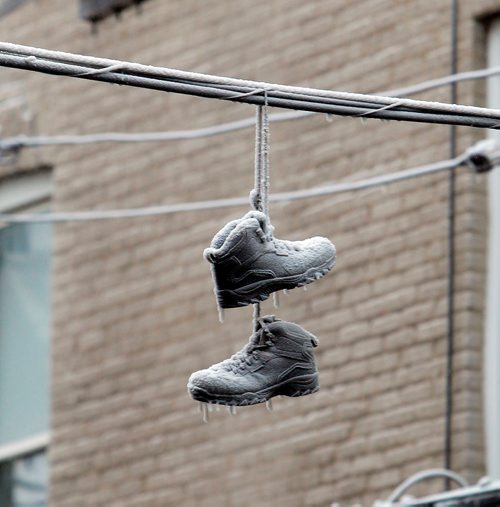 BORIS MINKEVICH / WINNIPEG FREE PRESS
Apartment fire that started last night at around 10:45pm at 489 Furby Street (near Ellice Ave.) These frosty shoes hang from a wire in the back lane of the address. Dec. 5, 2017