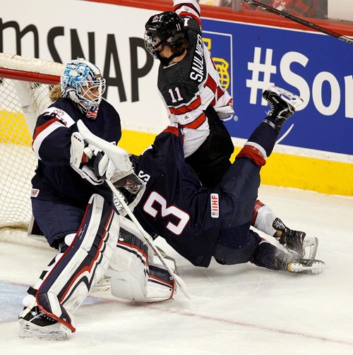 PHIL HOSSACK / WINNIPEG FREE PRESS  - Team Canada #11 Jillian Saulnier and USA's #3 Cayla Barnes tumble behind USA netminder #33 Alex Rigsby after falling over her stick at MTS Place Tuesday evening. See story.. -  December 5, 2017