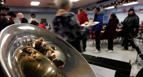 PHIL HOSSACK / WINNIPEG FREE PRESS  - With the Salvation Army Band reflected in one of it's tuba's, a volunteer heads out with a plate full of Christmas dinner as hungry participants file in for the annual Salvation Army Christmas Dinner. Over 1000 were served last Christmas, the Sally Anne cooks were prepped for 1200 this year and were dishing it out to 150 at each sitting. See release. -  December 6, 2017