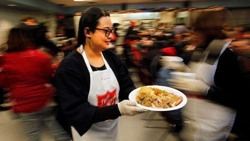 PHIL HOSSACK / WINNIPEG FREE PRESS  - Miriam Delos Santos serves up a plate full of Christmas dinner as hungry participants file in for the annual Salvation Army Christmas Dinner. Over 1000 were served last Christmas, the Sally Anne cooks were prepped for 1200 this year and were dishing it out to 150 at each sitting. See release. -  December 6, 2017