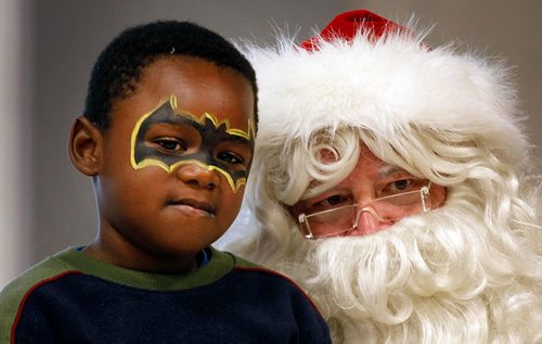 PHIL HOSSACK / WINNIPEG FREE PRESS  - STAND-UP Masked Men -- Benel Lumbebele poses with Santa Saturday afternoon at the 7th annual Newcomers Emplyoment & Education Development Services (NEEDS) Winter Festival, Benel and his family came to Canada from Zimbabwe.  See release . -  December 9, 2017