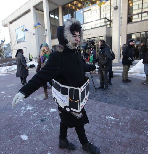 RUTH BONNEVILLE / WINNIPEG FREE PRESS

FIGHTING FARE HIKE:  Annie Beach cones a cardboard bus around her waist as she rally's with others  in support of Winnipeg Transit outside City Hall Monday.  
Maggie MacIntosh (intern)

Dec 11, 2017