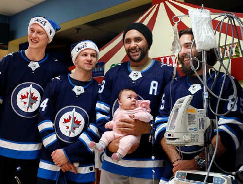 WAYNE GLOWACKI / WINNIPEG FREE PRESS

Seven players from the Winnipeg Jets met with young patients at the HSC Children's Hospital Wednesday afternoon on their annual Christmas time visit.  Dustin Byfuglien holds eleven week old Madison with players from left, Tyler Myers, Josh Morrissey and Mathieu Perreault smiling for family pictures.  The players also visited patients in the wards and made an appearance on CHTV, the hospitals closed-circuit television station.   Dec. 13  2017