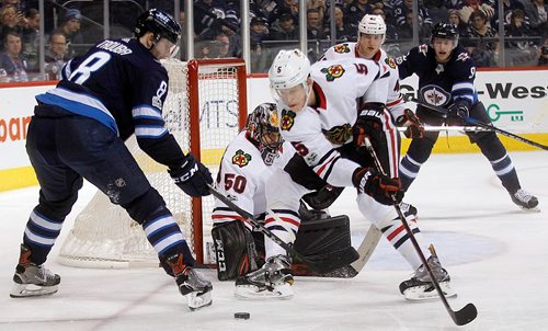 PHIL HOSSACK / WINNIPEG FREE PRESS  - Winnipeg Jet #8 Jacob Trouba and Chicago Black Hawk # 5 Connor Murphy work for the puck in front of Chicago netminder #50 Cory Crawford Thursday at Bell MTS Place.  - December 14, 2017