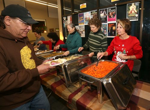 JASON HALSTEAD / WINNIPEG FREE PRESS

Volunteer Debbie Curtis serves carrots to artist Rob Slater at the West End Cultural Centre's annual holiday dinner and concert on Dec. 6, 2017. (See Social Page)