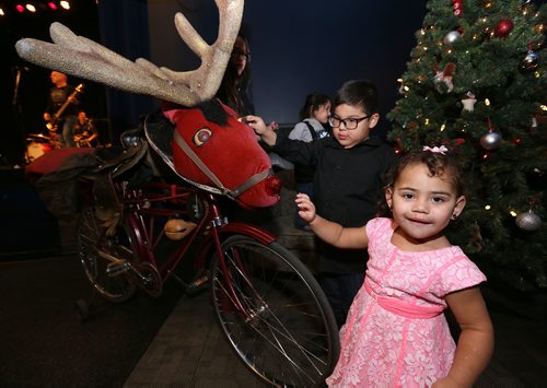 JASON HALSTEAD / WINNIPEG FREE PRESS

Isebella McKay, 1, and Quinton Qu'appelle, 5, check out emcee Al Simmons' Rudolphy bicycle at the West End Cultural Centre's annual holiday dinner and concert on Dec. 6, 2017. (See Social Page)