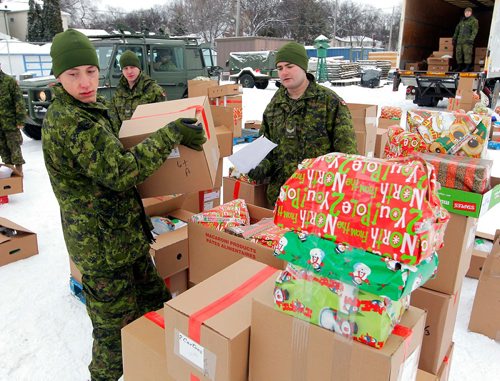 BORIS MINKEVICH / WINNIPEG FREE PRESS
Private Logan Doell, left, lifts a hamper box while Cpl Devin Twomey, right with paper in hand, makes sure the hampers are in order. Both are from the 38CER reserves (combat engineer regiment). A total of 80 army people helped out on the day. They got a truck load of hampers from the Christmas Cheer Board and sorted and distributed them to people in the north end. Photo taken at McGregor Armoury and was called Exercise Parcel Push where Army Reservists and Cadets took part. There were about 250 hampers delivered. Organized Fort Garry Horse (FGH). Dec. 16, 2017
