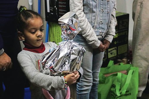 Canstar Community News Dec. 12, 2017 - Three-year-old Rhema holds onto a gift given to her family at the Habitat for Humanity ceremony to oficially hand over the keys to her home. (LIGIA BRAIDOTTI/CANSTAR COMMUNITY NEWS/TIMES)