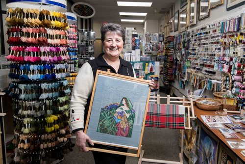 Sheena Buckner shows off two pieces of her cross stitch work inside her Needle Art Gallery Thursday evening. Dec. 21, 2017. Mike Sudoma / Winnipeg Free Press