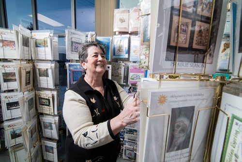 Sheena Buckner, owner of Sheenas Needle Art Gallery, looks through the hundreds of her cross stitch project books Thursday evening. Dec. 21, 2017 Mike Sudoma // Winnipeg Free Press