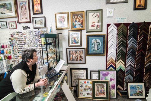 heena Buckner, owner of Sheenas Needle Art Gallery looking at her finished cross stitch projects Thursday evening. Dec. 21, 2017 Mike Sudoma // Winnipeg Free Press